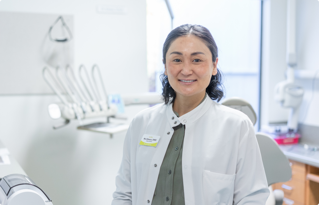 In a dental office, a woman with a beaming smile awaits her appointment.